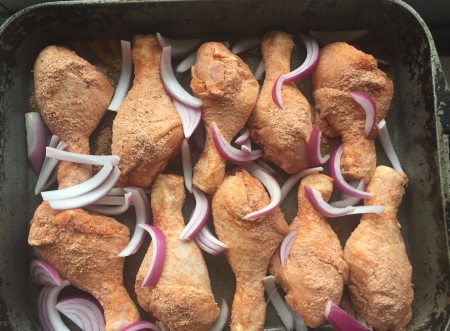 lay drumsticks in a baking dish with onion